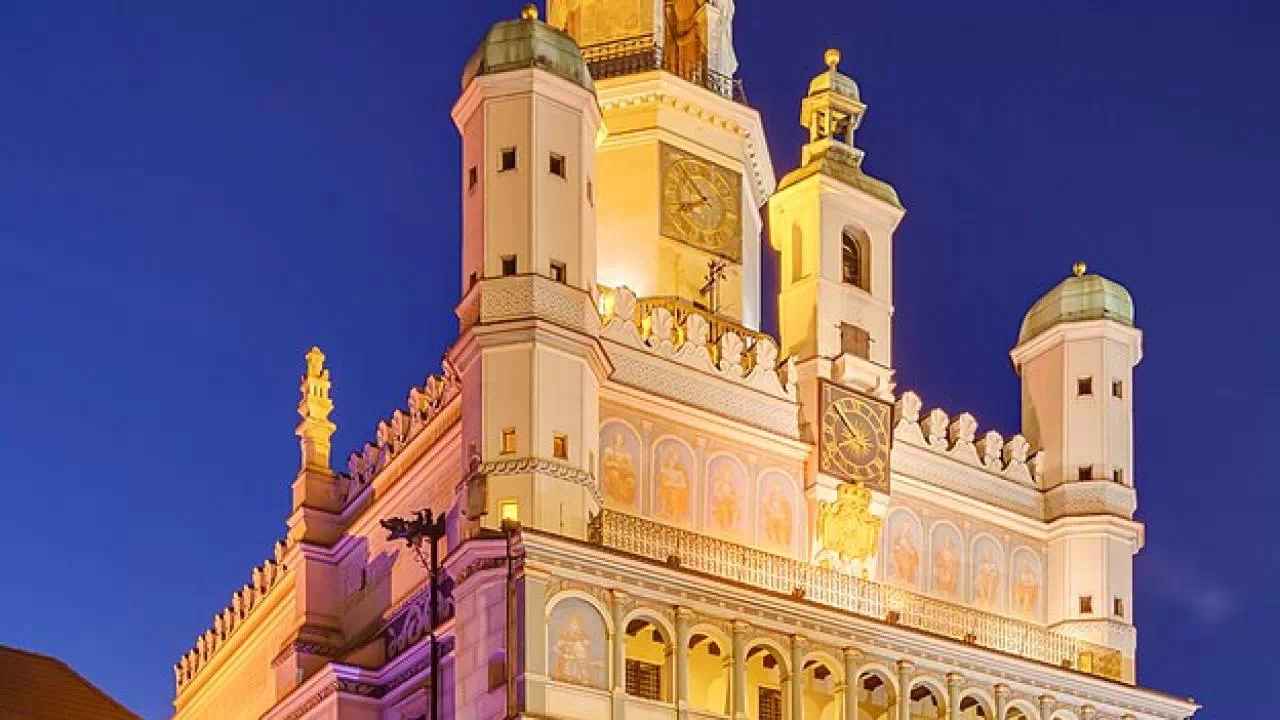Imponująca zabudowa ratusza w Poznaniu, która nocą jest podświetlona.