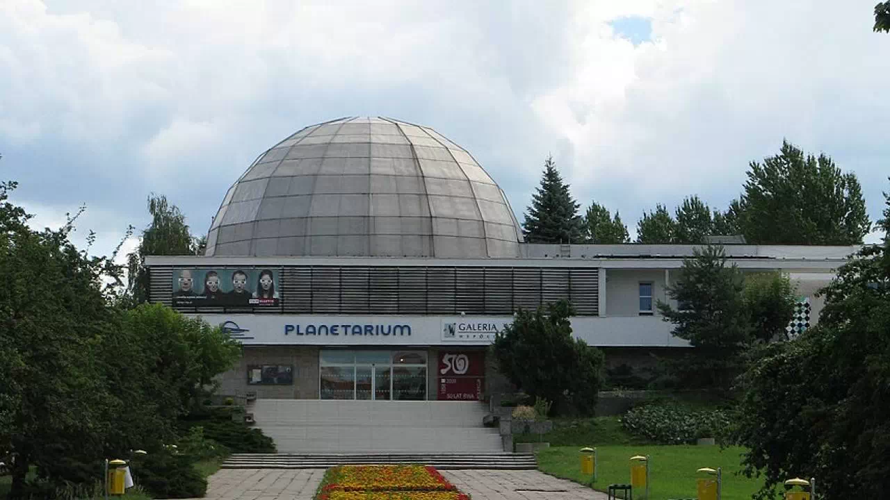 W samym Olsztynie można podziwiać cały kosmos za sprawą Olsztyńskiego Planetarium, które widać na zdjęciu. Budynek ma imponującą kopułę, a przed jego wejściem rozciąga się dywan kwiatowy.