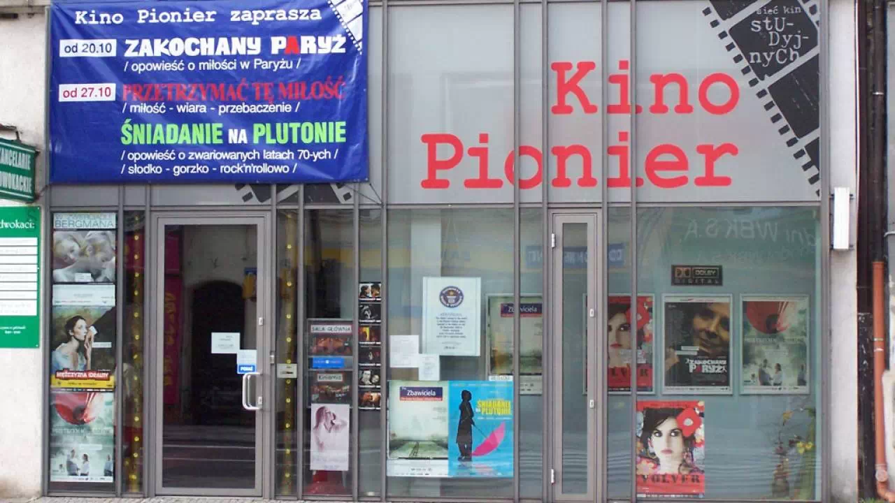 Widok na wejście do Kina Pionier w Szczecinie, które pokryte jest plakatami.