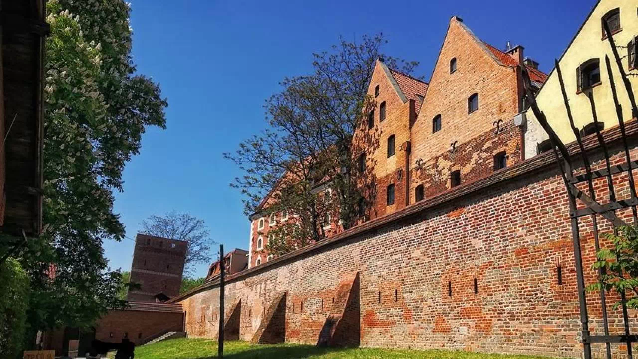 Rozgległe mury miejskie z czerwonej cegły, które mieszczą się w Toruniu