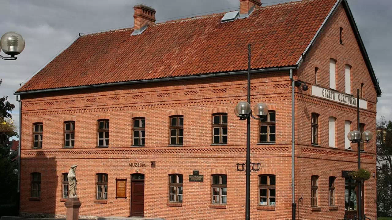 Muzeum z czerwonej cegły, przed którego budynkiem znajduje się rzeźba.